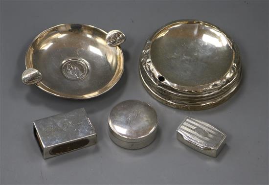 Two white metal pill boxes, two silver ashtrays and a silver match sleeve.